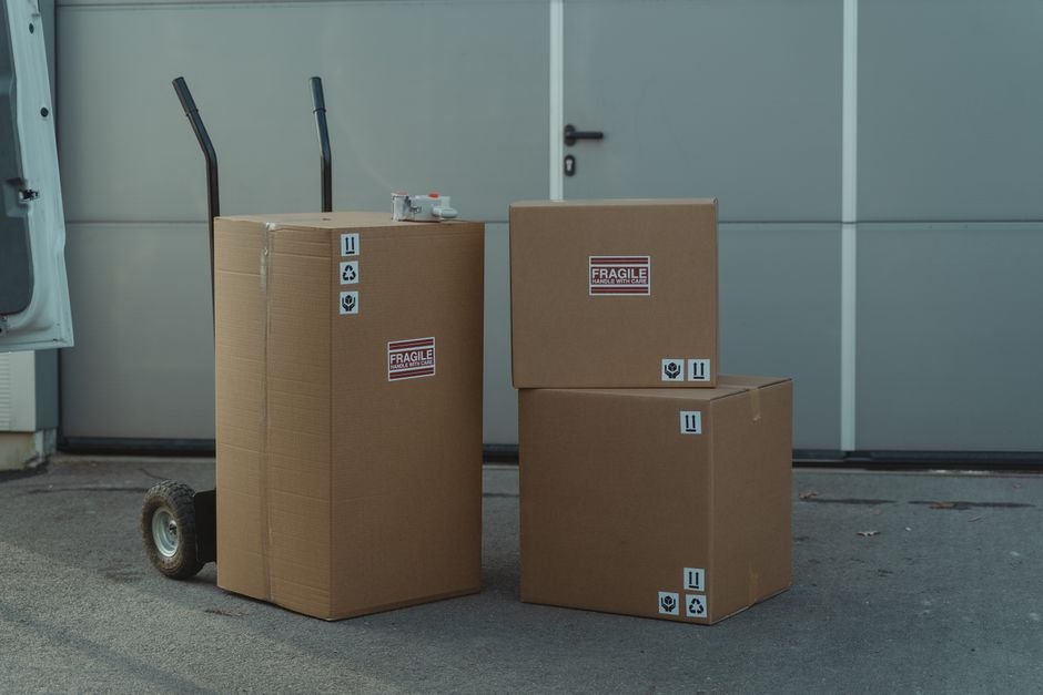 Cardboard boxes on a dolly ready to ship, representing the shipping cost of reselling LEGO sets