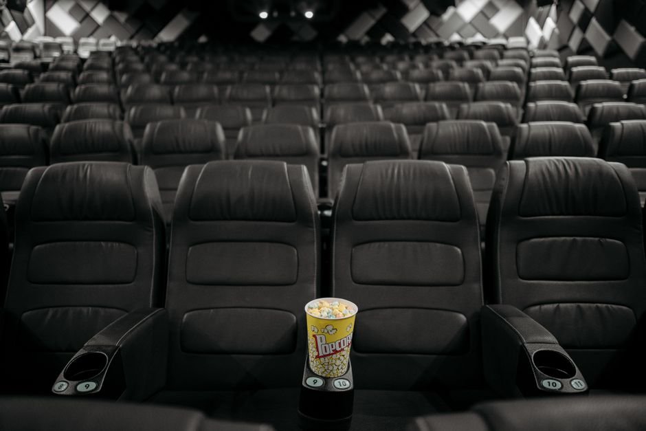 Empty cinema hall with black seats and popcorn