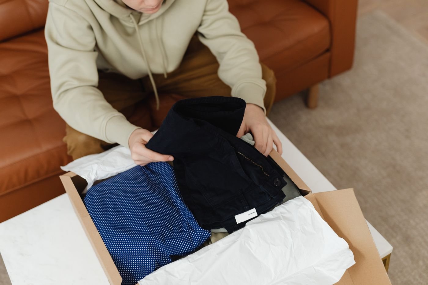 Person unboxing clothes ordered online from a cardboard box