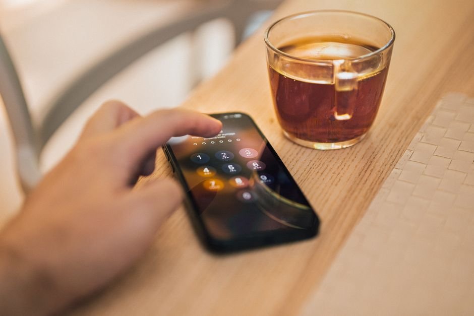 Hand unlocking a smartphone to check the Android security patch level