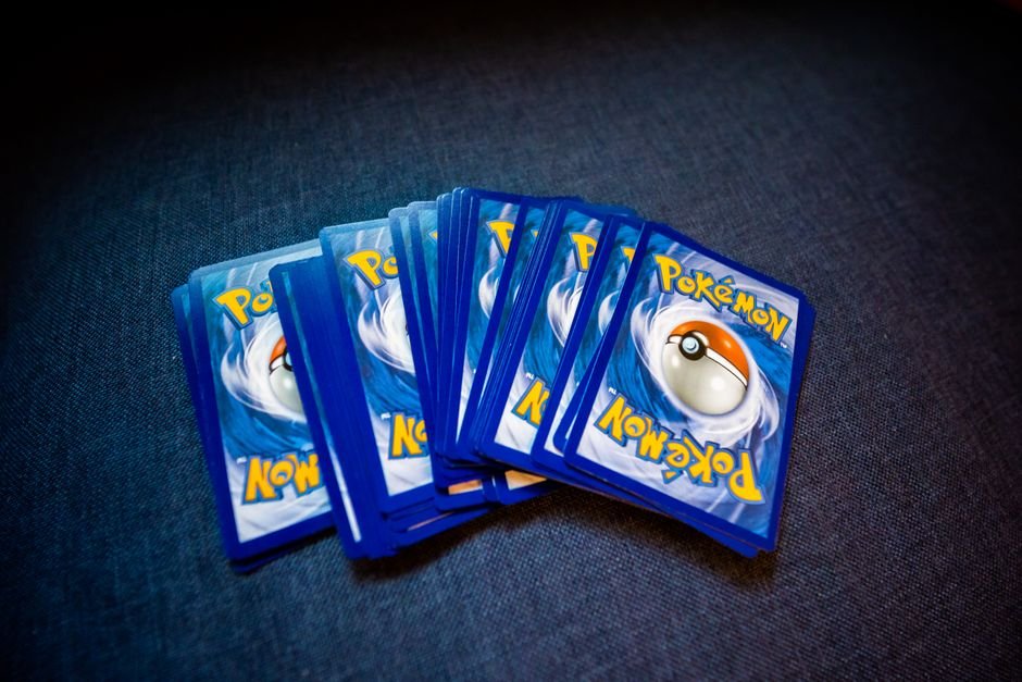 Trading cards laid out for sorting staple Trainer cards from a Pokemon deck product