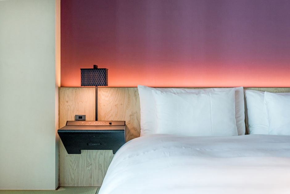 Compact Japanese hotel room with a made bed, booked through an online travel site