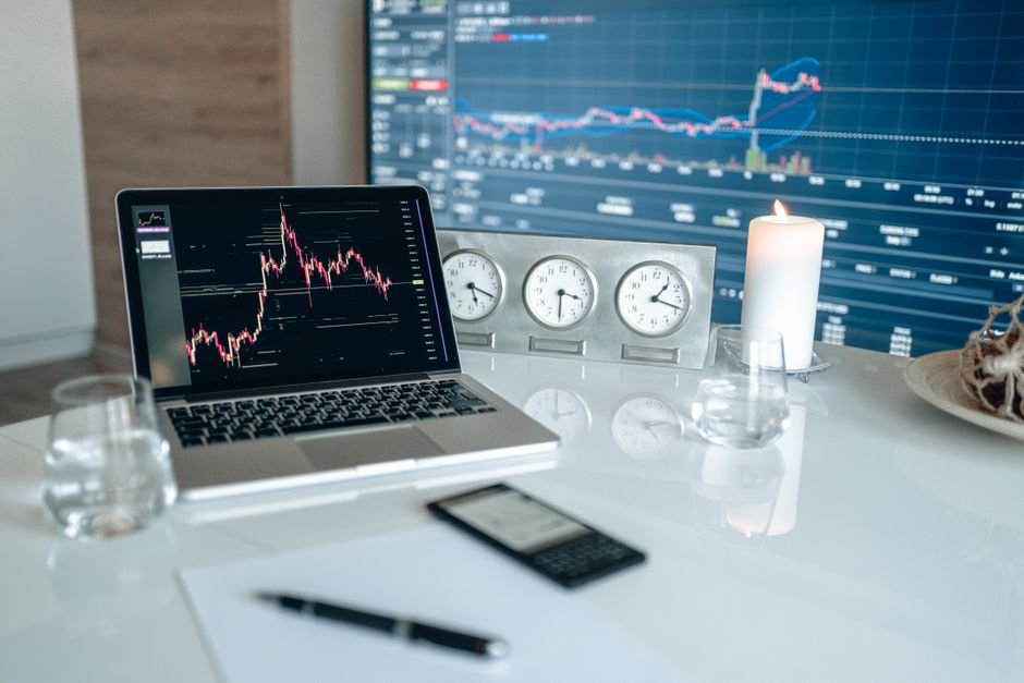 Workspace with financial charts and clocks on a white table