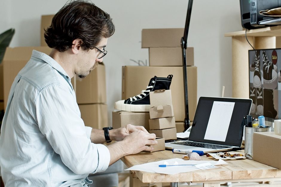 Seller packing products at a desk, representing fulfilling Amazon orders yourself instead of FBA