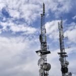 Telecommunication towers with antennas under a cloudy sky