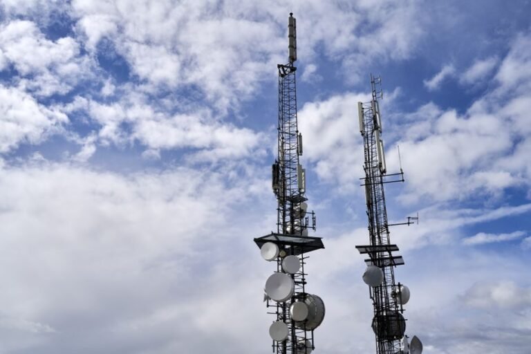Telecommunication towers with antennas under a cloudy sky