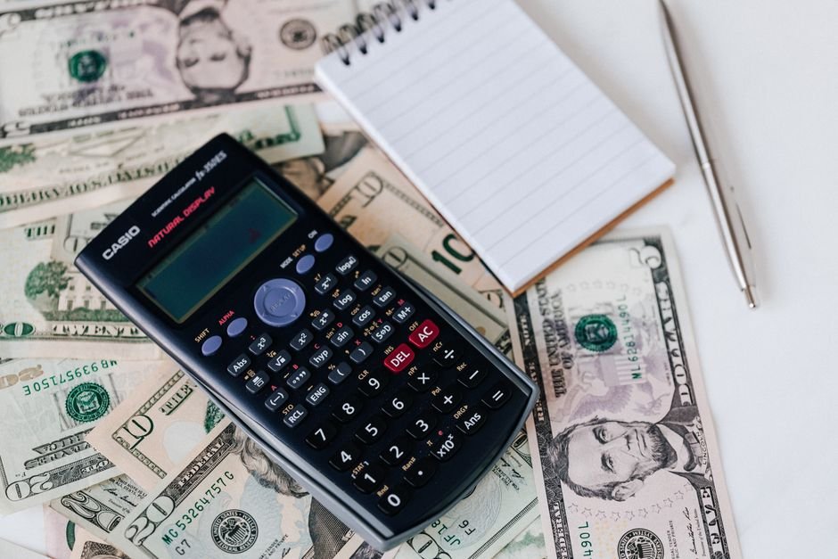 Calculator and notepad on US dollar bills, illustrating the math of a rate hike on Treasury holdings