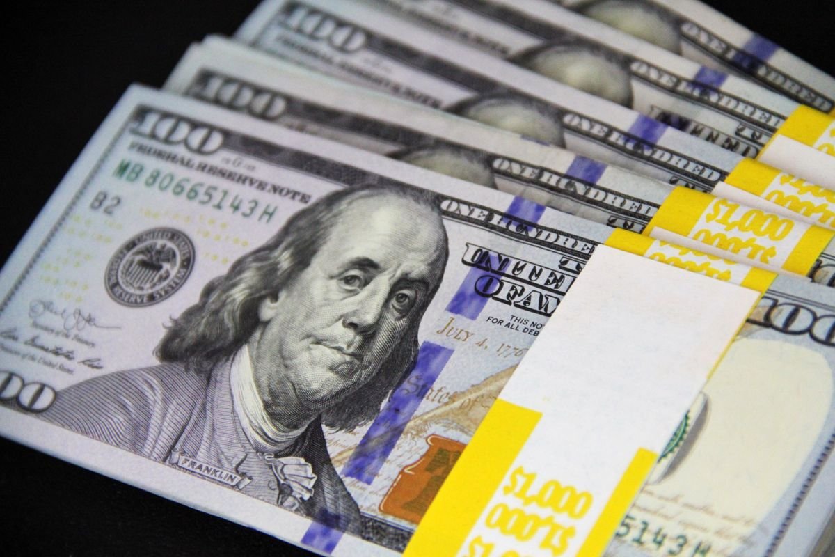 Stack of US hundred dollar bills on a dark surface, illustrating Treasury yields