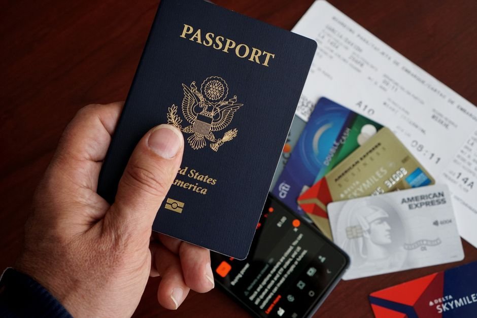 US passport with credit cards and travel documents, representing the cost of a Kenya ETA plus required insurance