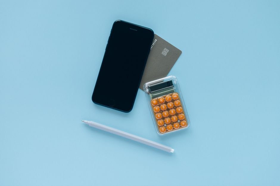 Smartphone, credit card and calculator on a blue background