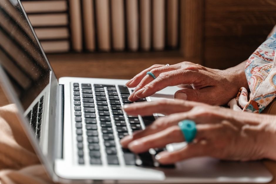 Person typing on an older laptop at home while checking Windows Update settings