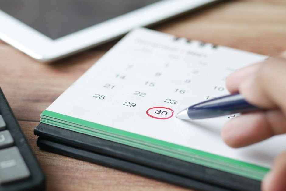 Hand marking a date on a calendar, representing the October 13, 2026 end of updates for Windows 11 24H2 Home and Pro